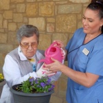 Tiffin House resident waters flowers with Tracy